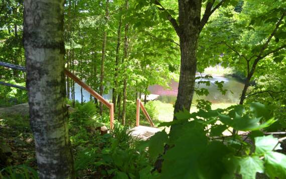Accès privé au mini lac avec chalet à louer en bois rond bord de l'eau Le Rustique