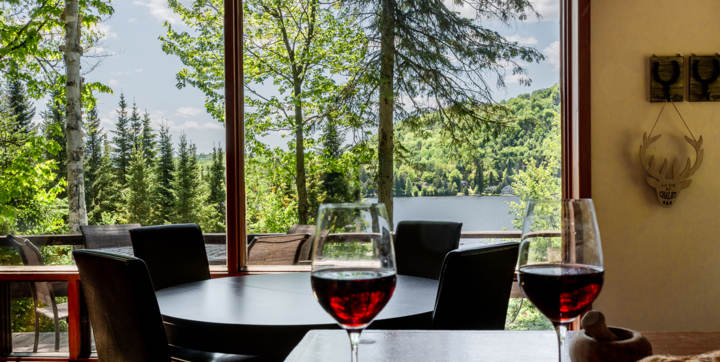 Salle à dîner chalet vacances en bois Le Sariane avec vue sur le lac sauna et spa privés Laurentides