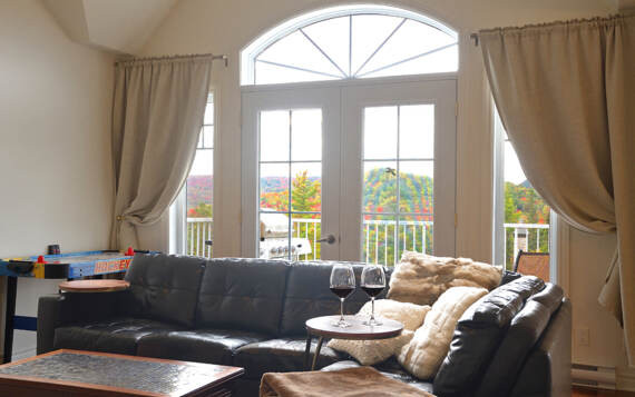 Salon avec accès à la terrasse très ensoleillé du chalet à louer de La Montagne Lanaudière Chalets Booking