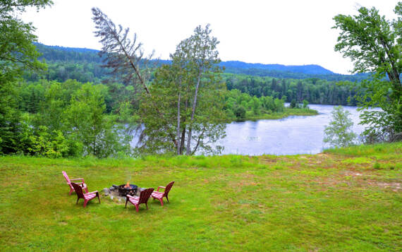 Vue de la terrasse foyer extérieur privé chalet en location Gros Pin avec bois chauffage inclus et vue sur la rivière Saint-Maurice Domaine McCormick