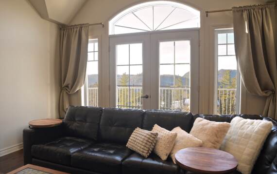 Salon avec foyer au propane chalet de La Montagne en location avec une vue magnifique sur les montagnes à 400 mètres de la piste Val-Saint-Côme