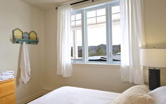 Chambre avec grand lit (queen) literie propre blanche incluse avec location chalet en location de La Montagne Chalets Booking