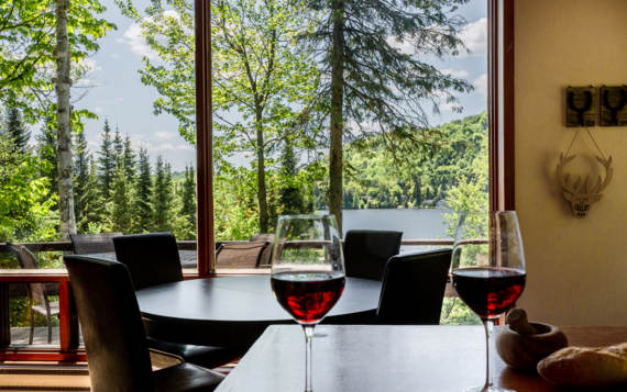 Salle à dîner chalet vacances en bois Le Sariane avec vue sur le lac sauna et spa privés Laurentides