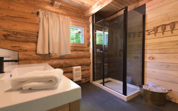 Toilette et douche porte en verre chalet bois ronds en location 