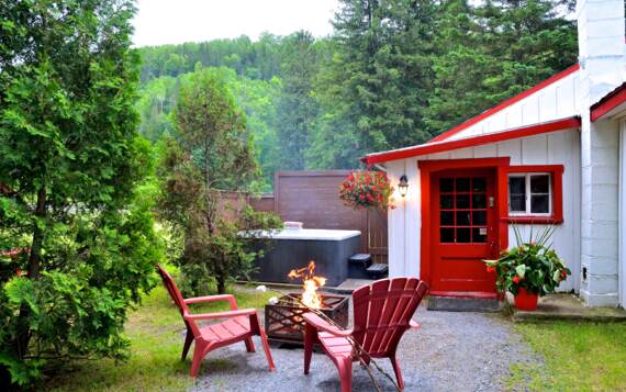 Cours arrière chalet vacances Lafontaine avec spa privé et foyer extérieur avec bois chauffage inclus Mauricie