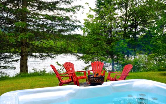 Spa privé et foyer extérieur au bord de la rivière Saint-Maurice chalet vacances en bois Pignon Nord Domaine McCormick 