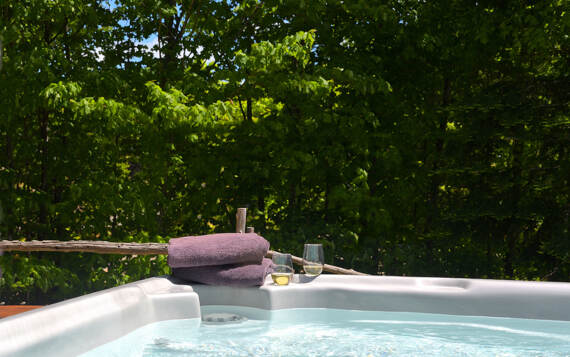 Jacuzzi extérieur privé 4 saisons chalet bois rond en location pour 2 à 4 personnes tout équipé au bord de l'eau Domaine Chalets Booking