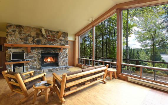 Salon avec foyer et cheminée en pierres chalet à louer Sariane pour 2 à 4 personnes Laurentides  vue sur l'eau