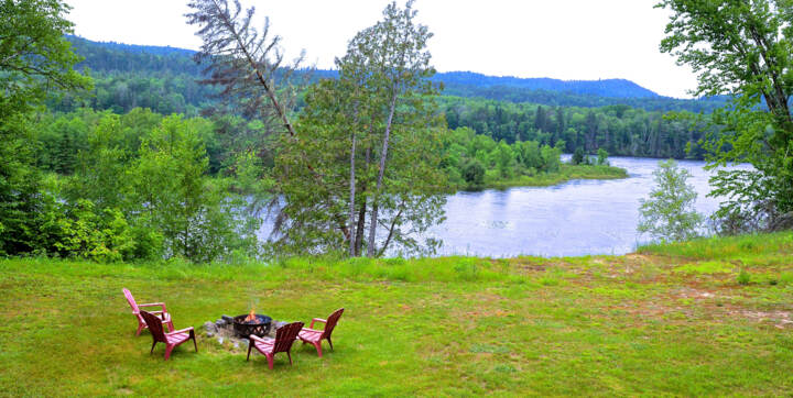 Vue de la terrasse foyer extérieur privé chalet en location Gros Pin avec bois chauffage inclus et vue sur la rivière Saint-Maurice Domaine McCormick