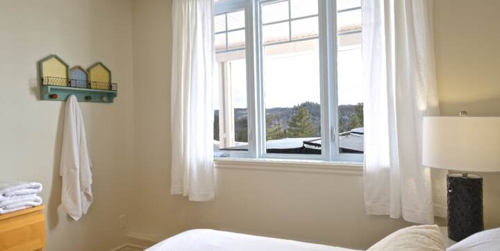 Chambre avec grand lit (queen) literie propre blanche incluse avec location chalet en location de La Montagne Chalets Booking