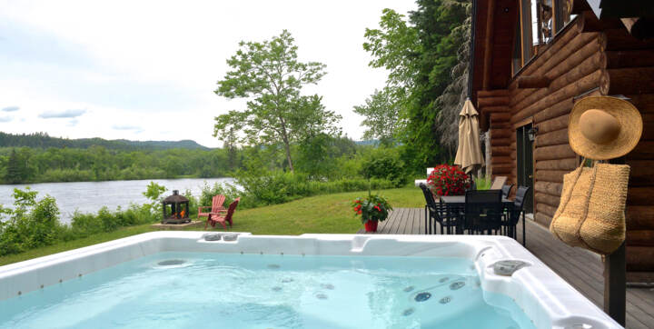 Spa privé et terrasse arrière avec ensemble patio au bord de l'eau avec vue sur rivière et montagnes Mauricie