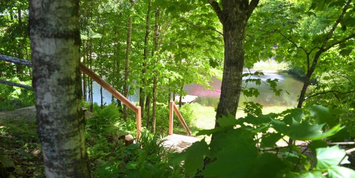 Accès privé au mini lac avec chalet à louer en bois rond bord de l'eau Le Rustique