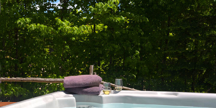 Jacuzzi extérieur privé 4 saisons chalet bois rond en location pour 2 à 4 personnes tout équipé au bord de l'eau Domaine Chalets Booking