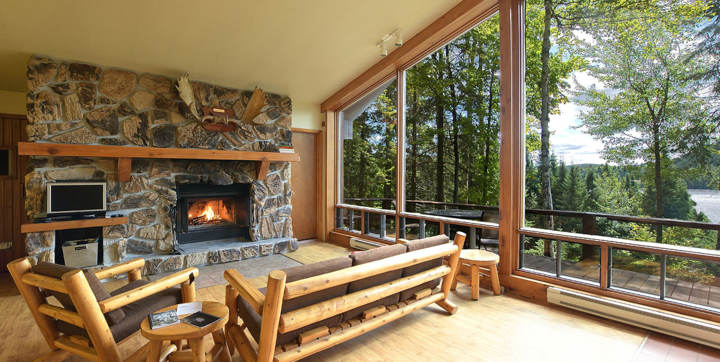 Salon avec foyer et cheminée en pierres chalet à louer Sariane pour 2 à 4 personnes Laurentides  vue sur l'eau