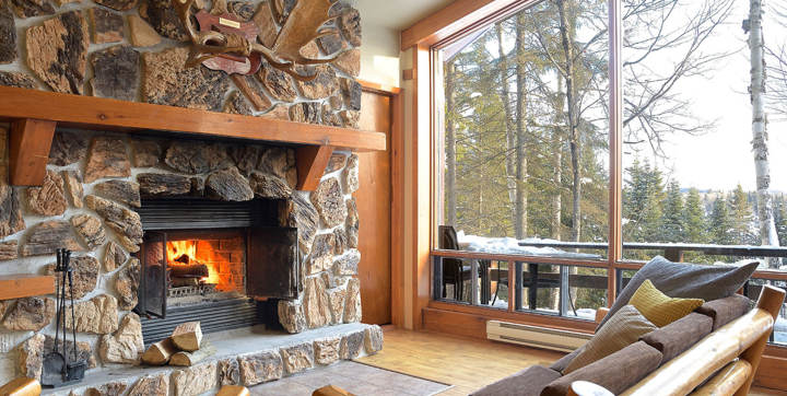 Foyer avec bois chauffage inclus chalet vacances Laurentides avec sauna et spa privé vue sur l'eau